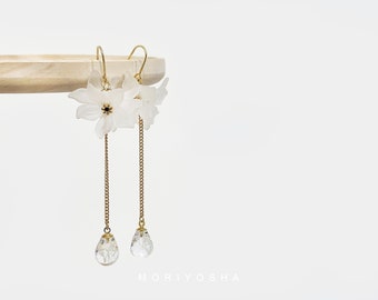 May include: White flower dangle earrings with a gold chain and clear crystal drops.