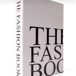 Peut inclure: Un livre blanc avec du texte noir qui dit "THE FASHION BOOK" sur le dos et "THE FASHION BOOK" sur la couverture.