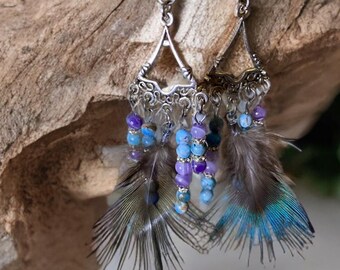 Tibetan silver drop earrings with real feathers and glass beads. Also silver plated crystal spacers. And blue peacock feathers.