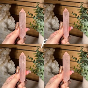 May include: Four images of a pink rose quartz crystal point. The crystal is held in a hand with a glittery nail. The crystal is a pale pink color and has a pointed tip. The background includes greenery and a wooden surface.