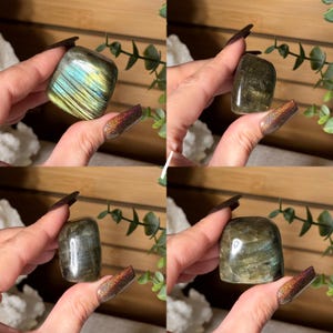 May include: Four polished labradorite stones in various shapes and sizes. The stones display iridescent flashes of blue, green, and gold. Each stone is held in a hand, showcasing the natural beauty and unique patterns of the crystals.