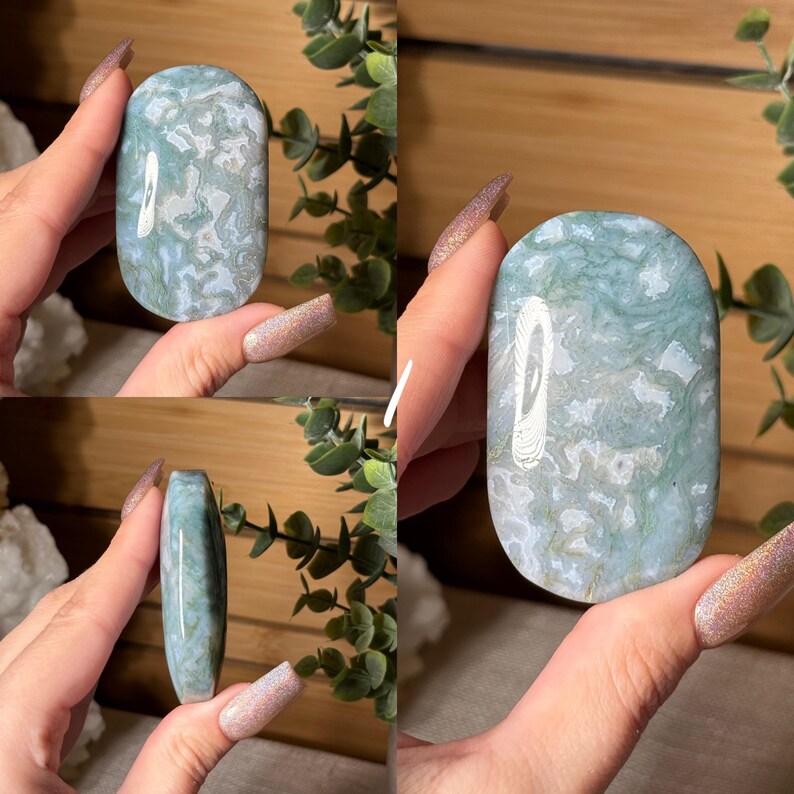May include: A polished, oval-shaped gemstone with a mottled pattern of light blue and white. The stone is held in a hand, showcasing its smooth surface and natural variations. The gemstone is a decorative item.