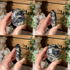May include: Four views of a polished oval stone. The stone features a mix of blue, gray, and white patterns. The stone is held in a hand, with a wooden background and greenery in the background.
