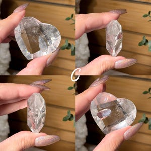 Puede incluir: Se muestran cuatro cristales de cuarzo transparente. Dos tienen forma de coraz&oacute;n y dos son puntas alargadas y facetadas. Los cristales se sostienen sobre un fondo natural, mostrando su claridad y forma. La letra "C" es visible.