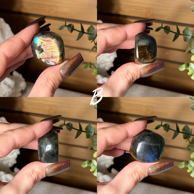 May include: Four polished labradorite stones in various shapes and colors are displayed. The stones range from iridescent blues and golds to darker grays and greens. The letter "B" is visible in white script.