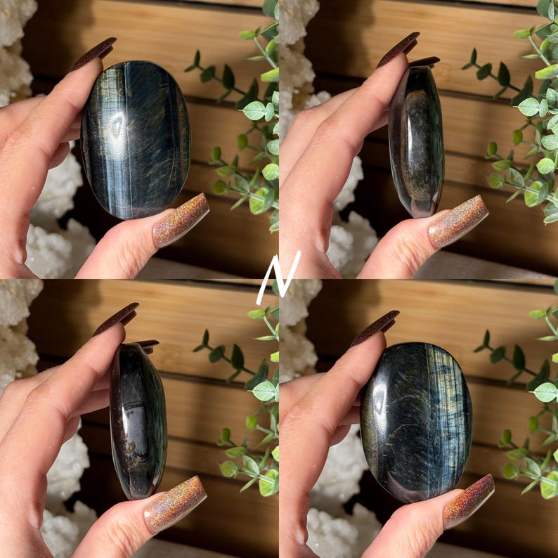 May include: Four views of an oval-shaped blue tiger's eye gemstone. The polished stone has a dark blue base with shimmering golden-yellow and blue bands. The gemstone is held in a hand against a background of greenery.