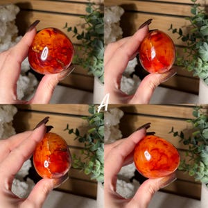 Puede incluir: Cuatro im&aacute;genes de una piedra pulida en forma de huevo de cornalina, sostenida en una mano. La piedra tiene un color naranja y rojo vibrante con patrones naturales. La letra "A" est&aacute; en texto blanco en el centro de la imagen.