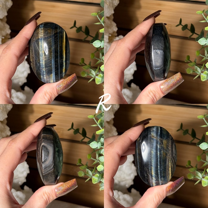 May include: Four images of a polished, oval-shaped gemstone. The stone has a dark base color with streaks of blue and gold. The gemstone is held in a hand, with a background of greenery and a wooden surface.