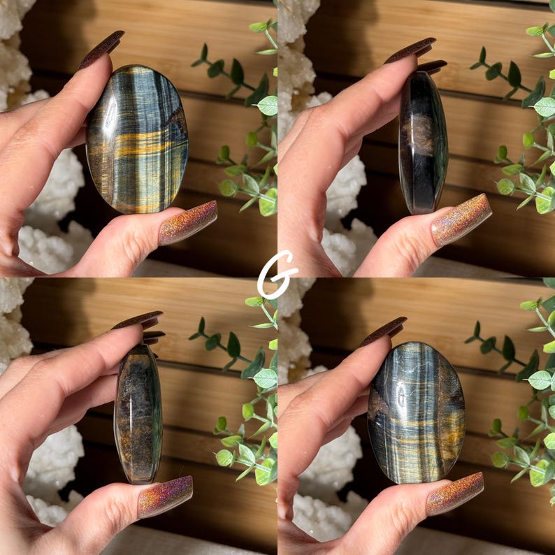 May include: An oval-shaped polished gemstone with blue and gold striations. The stone is held in a hand, showcasing its smooth, reflective surface. The gemstone's natural patterns create a unique, eye-catching appearance. The overall theme is crystals and gemstones.