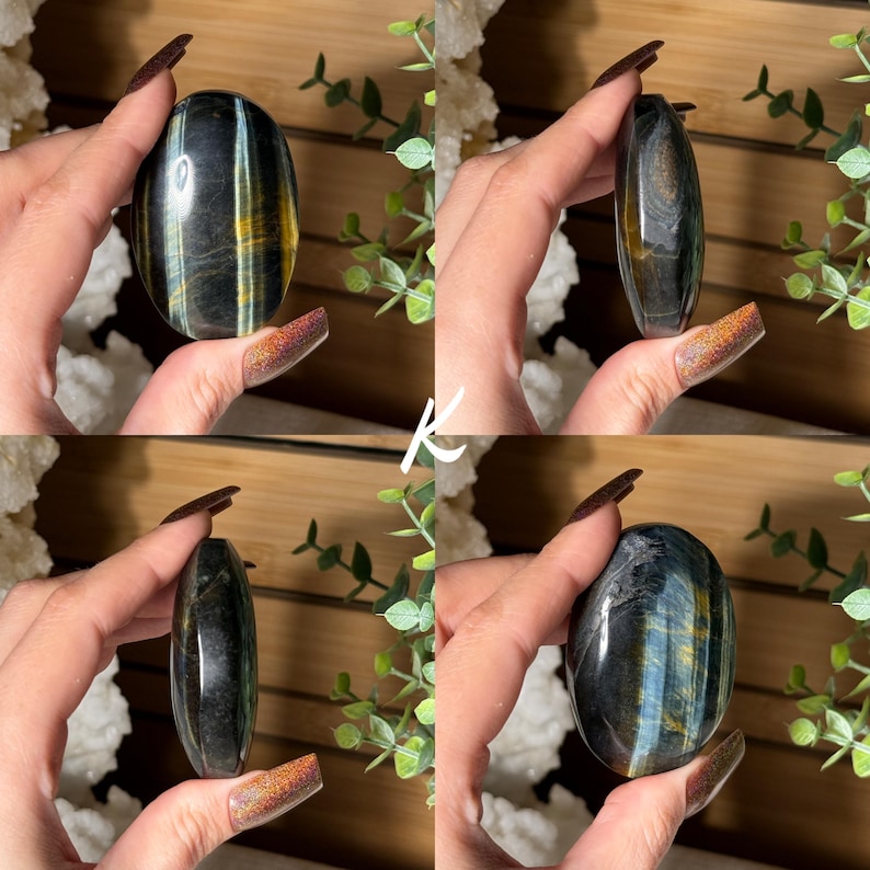 May include: Four images of a polished, oval-shaped gemstone. The stone has a dark blue base with streaks of gold and lighter blue. The gemstone is held in a hand, showcasing its smooth, reflective surface. The background includes greenery and white crystals.