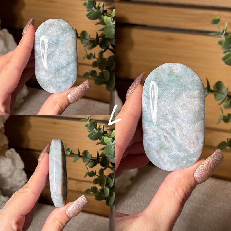 May include: A polished, oval-shaped stone with a marbled pattern of white and pale green. The stone is held in a hand, showcasing its smooth surface and natural variations. The stone's edges are rounded, and the overall aesthetic is organic and calming.