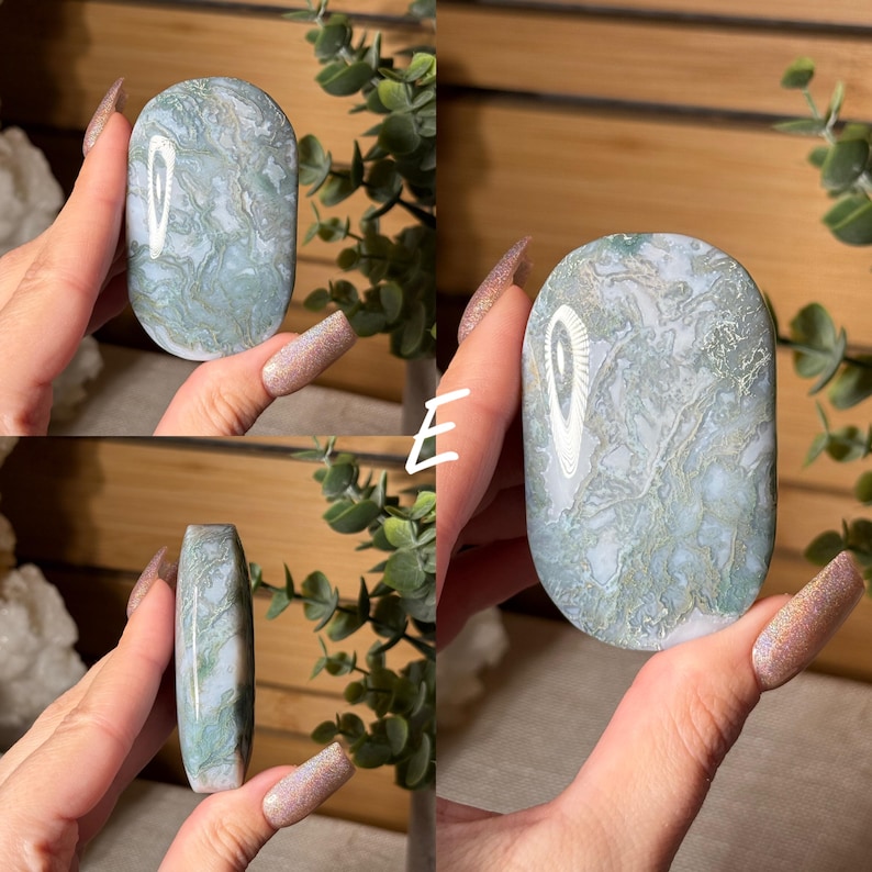 May include: A polished, oval-shaped stone with a marbled pattern of pale green and white. The stone is held in a hand, showcasing its smooth surface and natural variations. The letter "E" is visible in the image.