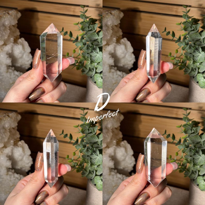 May include: Four clear quartz crystal points, each held in a hand. The crystals are transparent with a pointed tip. The word "Imperfect" is written in white script. Green plants and white crystals are in the background.
