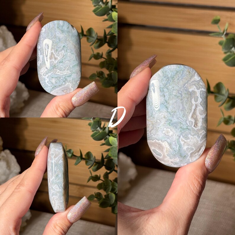 May include: A collection of four images showcasing a polished, oval-shaped stone. The stone features a blend of light blue, white, and gray patterns. The letter "D" is visible in one of the images. The stone is held in a hand, with greenery in the background.