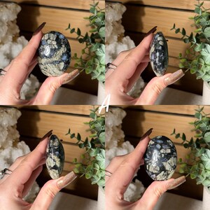 May include: Four images of an oval-shaped stone with a polished surface. The stone features a mix of black, gray, and blue patterns. The stone is held in a hand, with the letter "A" in white text in the center of the images.