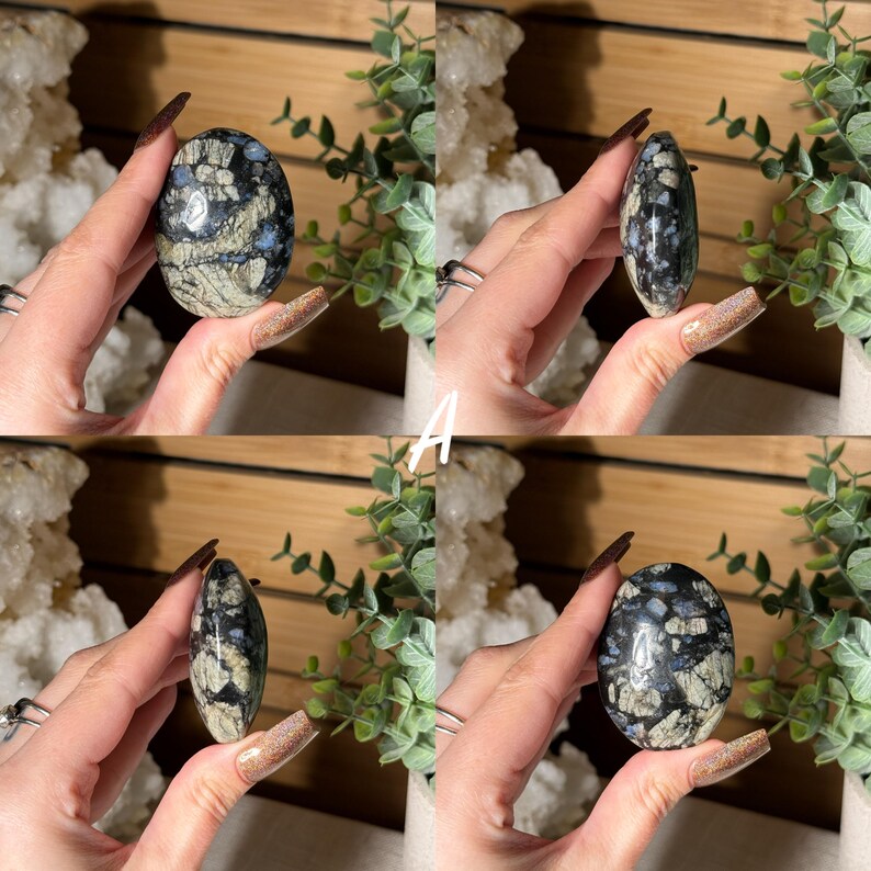 May include: Four images of an oval-shaped stone with a polished surface. The stone features a mix of black, gray, and blue patterns. The stone is held in a hand, with the letter "A" in white text in the center of the images.