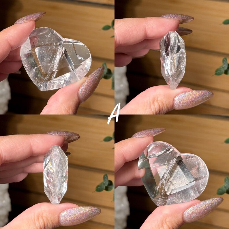 Puede incluir: Cuatro piezas de cristal de cuarzo transparente. Dos tienen forma de coraz&oacute;n y dos son puntiagudas. Los cristales se sostienen sobre un fondo de madera. La letra "A" est&aacute; escrita en blanco en la imagen.