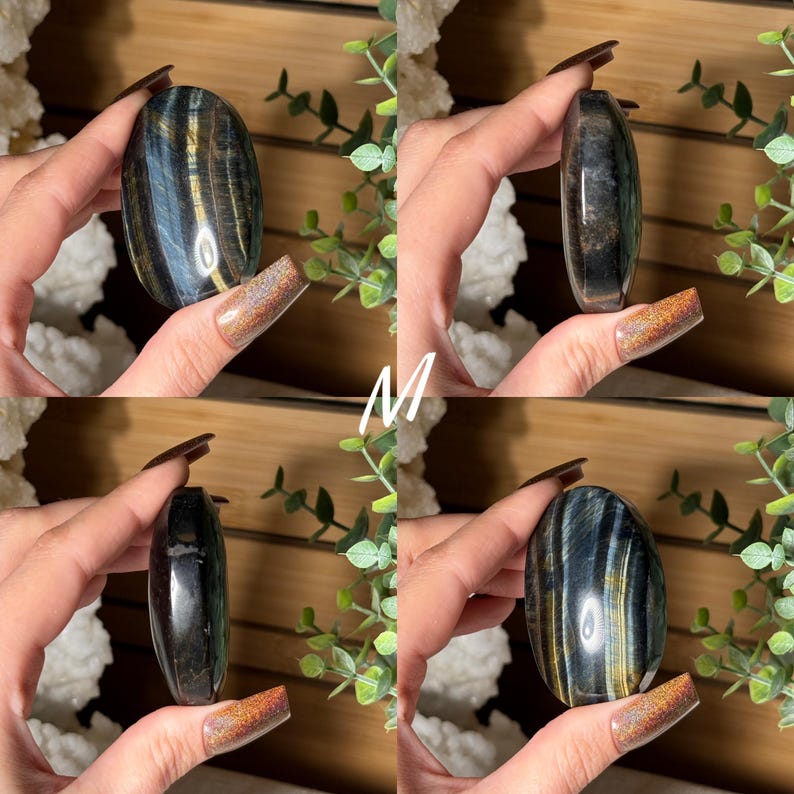 May include: Four polished oval-shaped gemstones with a mix of blue, gold, and black colors. The gemstones are held in hands, showcasing their smooth, reflective surfaces. The letter "M" is visible in white in the center of the image. The gemstones are a natural product.