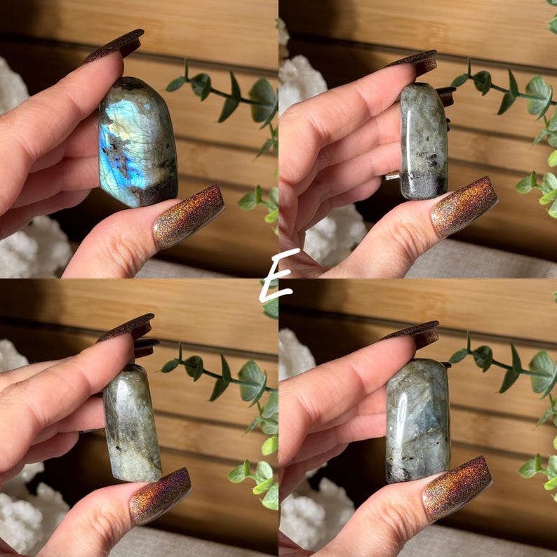 May include: Four images of polished labradorite crystals. The crystals vary in shape, with some being rounded and others rectangular. The stones display a mix of gray, blue, and iridescent colors. The crystals are held up against a background of greenery.