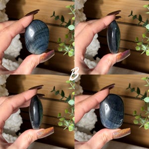 May include: Four images of polished blue tiger eye stones. The stones are oval-shaped and held in a hand. The stones have a chatoyant effect, with bands of color that shimmer in the light. The background includes greenery and a wooden surface.