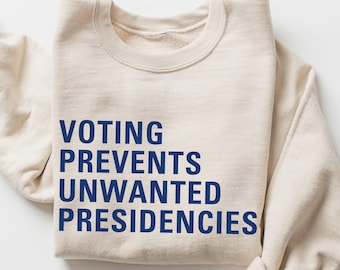May include: A beige sweatshirt with the text "Voting Prevents Unwanted Presidencies" printed in blue.