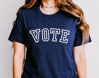 May include: A navy blue t-shirt with the word "VOTE" printed in white with a varsity-style font.