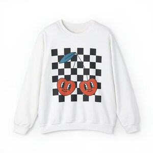 May include: White sweatshirt with a black and white checkered pattern and a graphic of two red cherries with smiling faces.