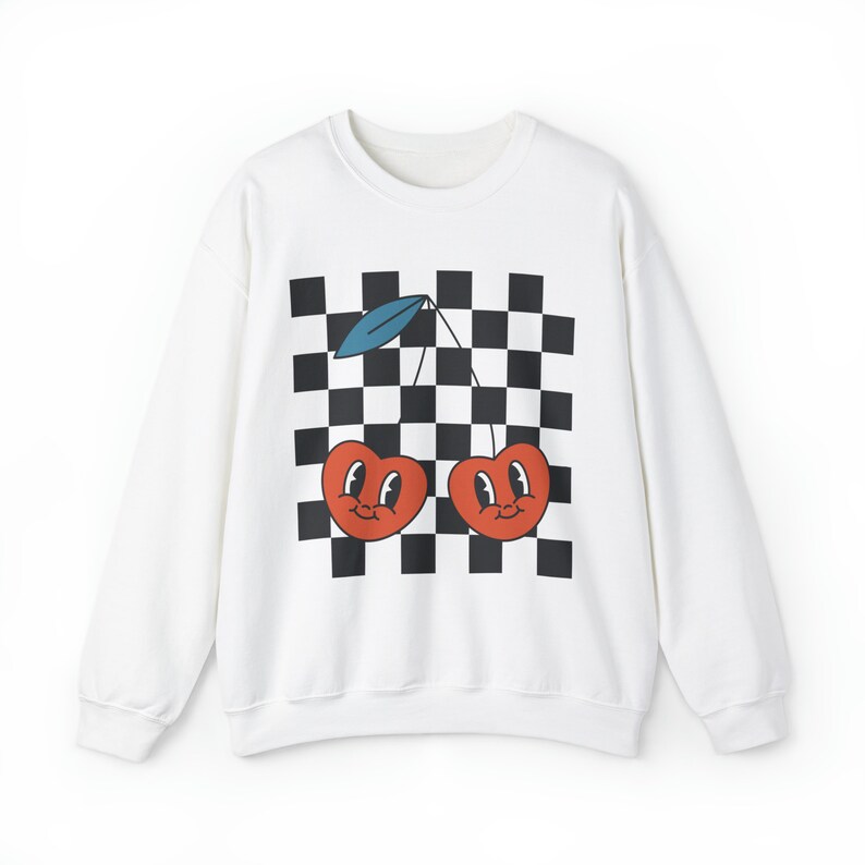 May include: White sweatshirt with a black and white checkered pattern and a graphic of two red cherries with smiling faces.