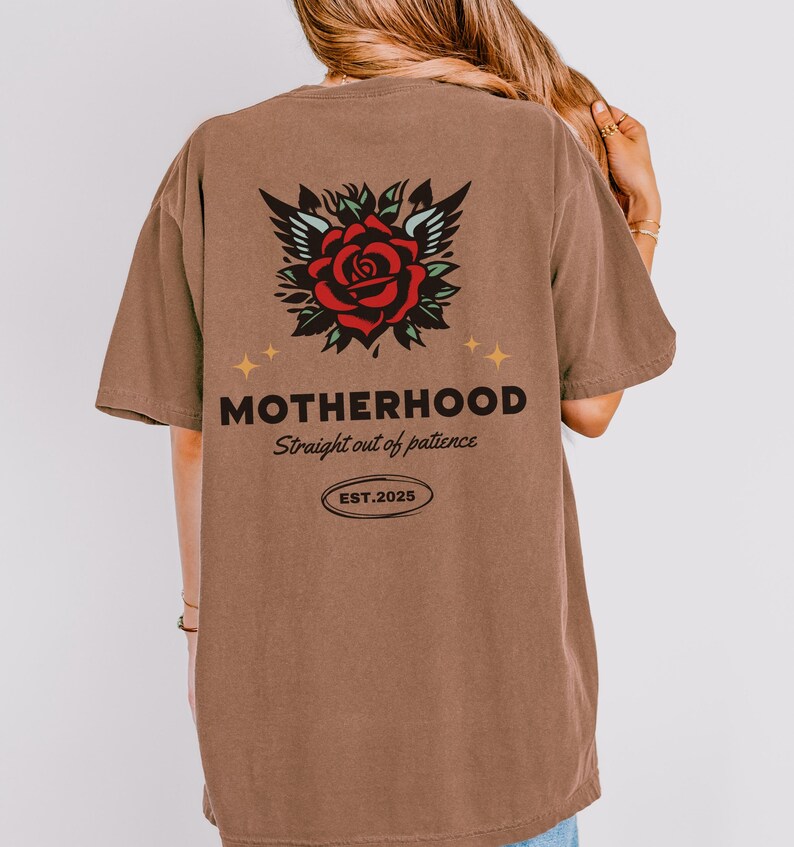 May include: Brown t-shirt with a red rose and wings graphic on the back. The text "MOTHERHOOD Straight out of patience EST. 2025" is printed below the graphic.