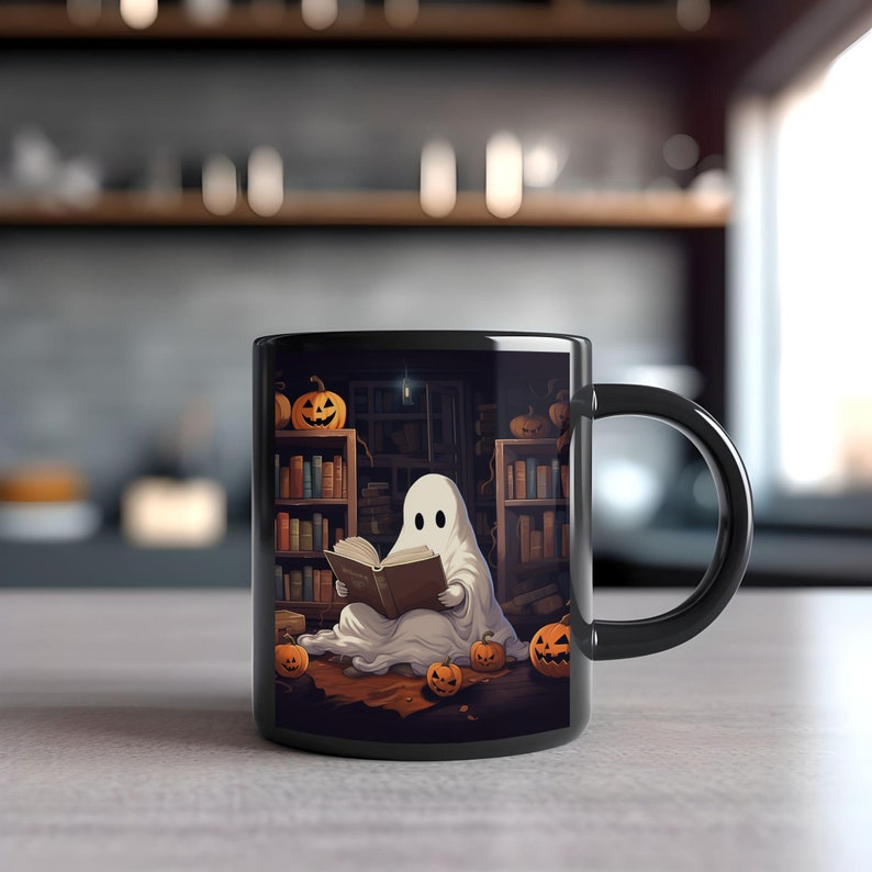 May include: Black coffee mug featuring a white ghost reading a book in a library setting with pumpkins and bookshelves.