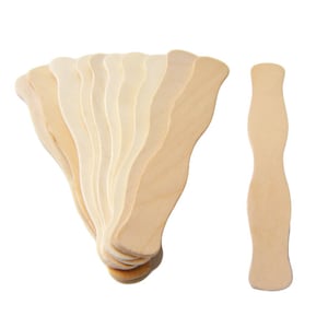 May include: A stack of 12 wooden craft sticks with a wavy edge. The sticks are light brown and have a natural wood finish. One stick is laying flat to the side.