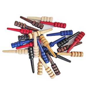 May include: A pile of wooden game pieces in red, blue, and natural wood colors. The pieces are shaped like small, pointed sticks with a rounded end. They are used for a game of skill and strategy.