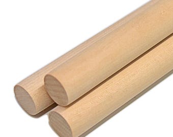 May include: Three cylindrical wooden dowels with a smooth, light tan finish. Each dowel features a consistent circular cross-section and a straight, uniform length, showcasing the natural grain and texture of the light-colored wood material.