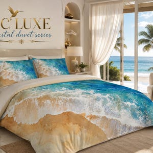 May include: A duvet cover set featuring a printed design of ocean waves crashing onto a sandy beach in shades of blue, turquoise, and tan. The text TC LUXE coastal duvet series is displayed on the wall above the bed with a gold hummingbird icon.