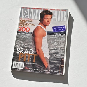Könnte beinhalten: Eine Ausgabe des Magazins Vanity Fair mit Brad Pitt auf dem Cover. Das Magazin trägt den Text "European Edition" und "America's Most Influential Women" auf dem Cover. Das Magazin liegt auf einer weißen Oberfläche.