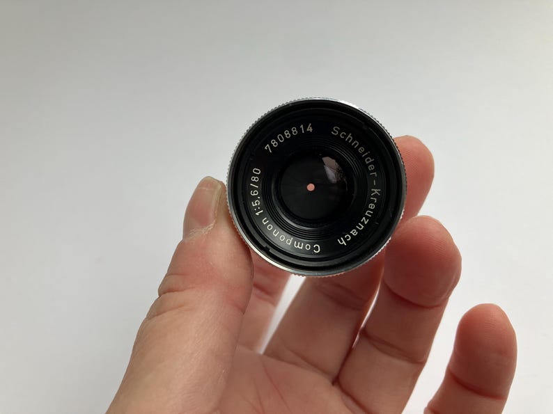 Puede incluir: Una taza de cer&aacute;mica blanca con un asa negra y el texto "But First, Coffee" en negro y negrita. La taza est&aacute; sobre una superficie blanca.
