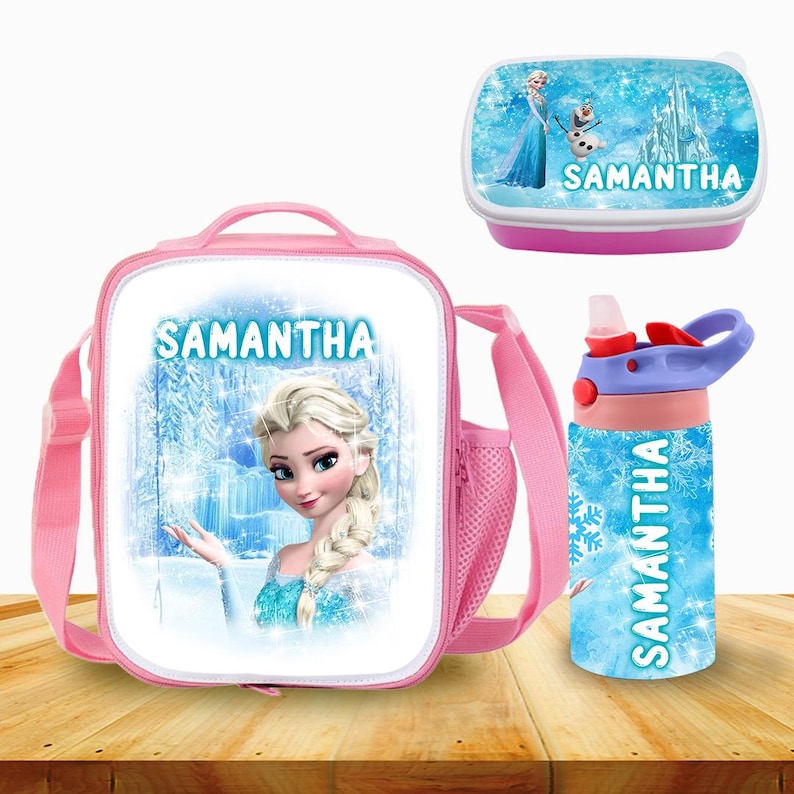 Puede incluir: Una bolsa de almuerzo rosa con un dise&ntilde;o de personaje de Frozen, una fiambrera rosa a juego con el nombre Samantha y una botella de agua azul con el nombre Samantha.
