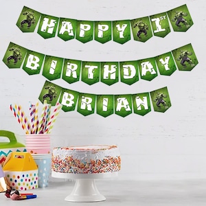May include: Green and white banner with the words "Happy 1st Birthday Brian" and images of the Hulk. The banner is hanging on a white wall.