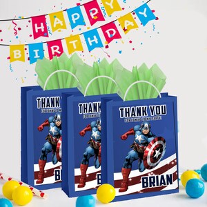 May include: Three blue gift bags with handles, featuring a cartoon image of Captain America. The bags have the text "Thank you for coming to my party!" and the name "Brian".