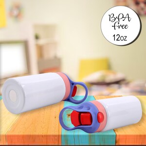 Puede incluir: Dos botellas de agua blancas de 12 onzas sin BPA con una tapa morada y rosa y un bot&oacute;n pulsador rojo. Las botellas est&aacute;n sobre una superficie de madera.