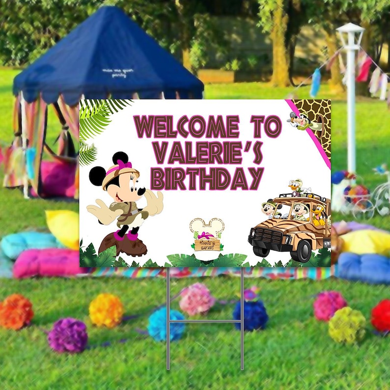 Peut inclure: Une pancarte de bienvenue pour une f&ecirc;te d'anniversaire avec une image de dessin anim&eacute; de Minnie Mouse v&ecirc;tue d'un costume de safari. La pancarte indique "Bienvenue &agrave; l'anniversaire de Val&eacute;rie" et a un th&egrave;me de jungle avec une jeep et d'autres animaux de safari.