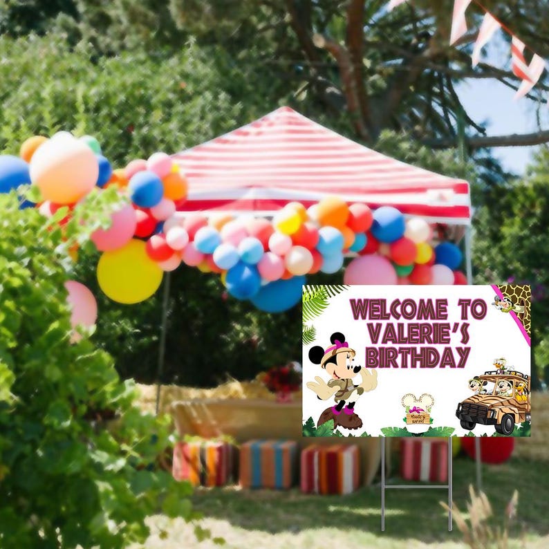 Peut inclure: Une pancarte de bienvenue pour une f&ecirc;te d'anniversaire avec une image de dessin anim&eacute; de Minnie Mouse v&ecirc;tue d'un costume de safari. La pancarte a un fond rose et blanc avec des feuilles vertes et un th&egrave;me jungle. Le texte sur la pancarte indique "Bienvenue &agrave; l'anniversaire de Val&eacute;rie".