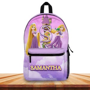 May include: A purple backpack featuring a princess design with long blonde hair and a purple dress. The backpack has a front pocket and the name "SAMANTHA" in yellow letters. The background is a purple sky with clouds.