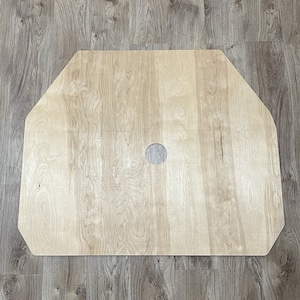 May include: A light wood octagonal shaped board with a round hole in the center.