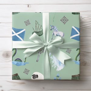 May include: A gift wrapped in light green paper with a repeating pattern of Scottish symbols. The design includes a unicorn, bagpipes, a Scottish flag, and the Loch Ness Monster. A light green satin ribbon and bow complete the presentation.