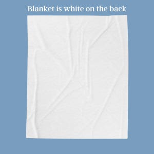 May include: A white blanket with a textured surface is displayed against a blue background. The text "Blanket is white on the back" is at the top. The blanket is folded and has visible creases.