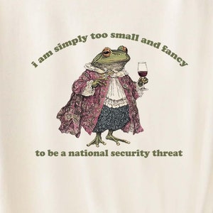 A shirt with a fancy frog that says I am simply too small and fancy to be a national security thread.
