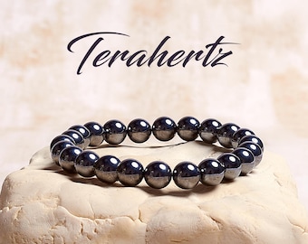 May include: A black terahertz beaded bracelet on a white surface. The bracelet is made of round beads and is approximately 8 inches in length.