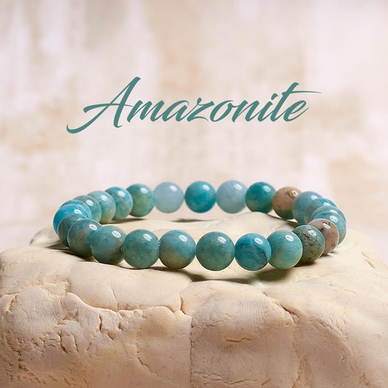 Puede incluir: Un brazalete de amazonita, una piedra preciosa de color azul verdoso. El brazalete est&aacute; hecho de cuentas redondas y est&aacute; enhebrado en un cord&oacute;n el&aacute;stico transparente.