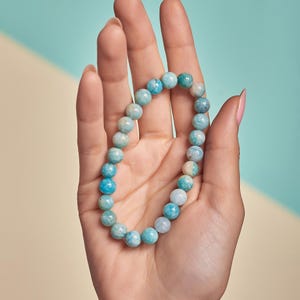 Puede incluir: Un brazalete de piedras preciosas azul y blanco con cuentas redondas. El brazalete est&aacute; hecho de piedras naturales y es perfecto para el uso diario.